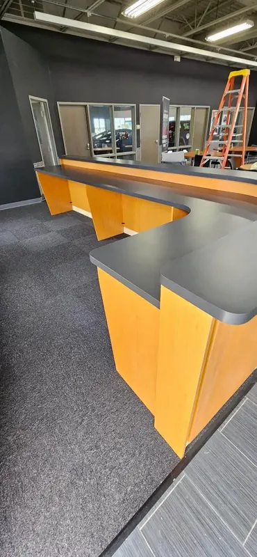 Two-level commercial service counter in maple laminate with a dark grey work surface