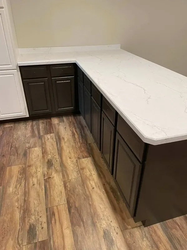 Corner kitchen counter in white marble-look laminate with grey veining over espresso cabinets