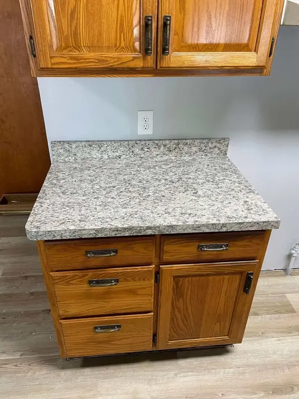 Grey speckled granite-look laminate top with coved backsplash on an oak base cabinet